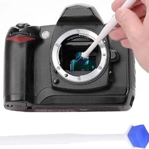 Obiettivo per fotocamere digitali con pinzette antistatiche e pennello per la pulizia.