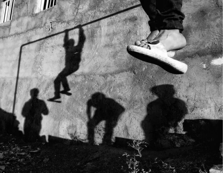 Sospensione e ombre di bambini che giocano, fotografia artistica in bianco e nero.
