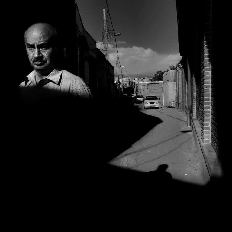 Uomo in ombra in strada urbana, fotografia in bianco e nero.
