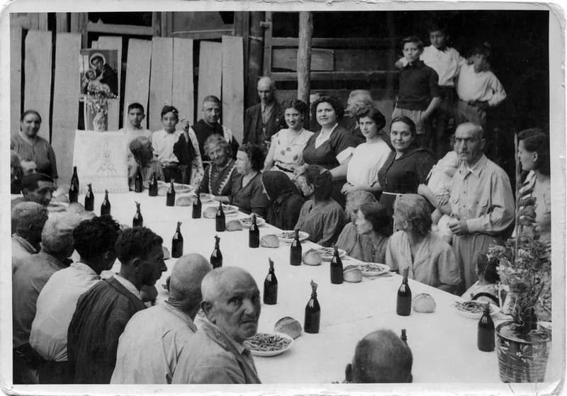 Vecchi ofrenda familia con tarta, fotografìa in bianco e nero, scena di gruppo, festa tradizionale italiana, ricordi d'infanzia, cultura italiana.