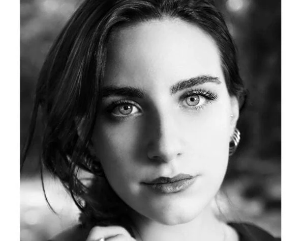 Ragazza con trucco naturale e capelli scuri, ritratto in bianco e nero.