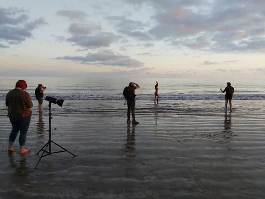 Fotografi di gruppo sulla spiaggia al tramonto, sessione fotografica all'aperto, ideale per stampe e album di ricordi.