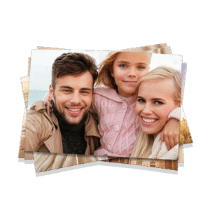Ragazza e due adulti sorridenti che tengono in mano fotografie di famiglia all'aperto.