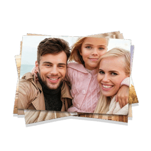 Ragazza e due adulti sorridenti che tengono in mano fotografie di famiglia all'aperto.