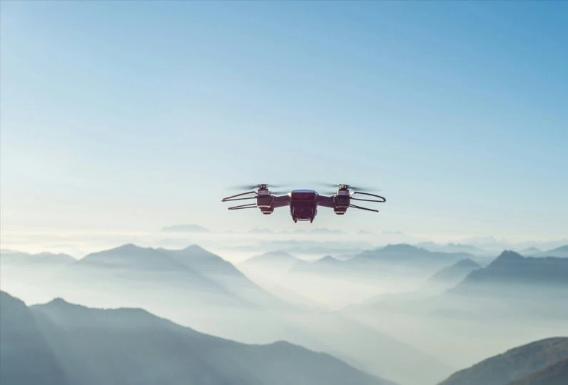 Drone in volo sopra le montagne con cielo sereno.