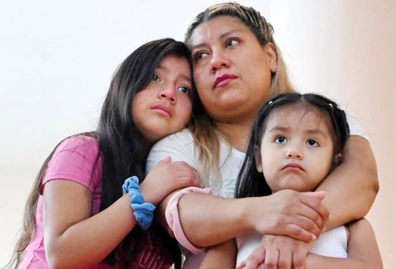 Madre con due bambine, abbraccio affettuoso, espressioni di conforto e protezione.