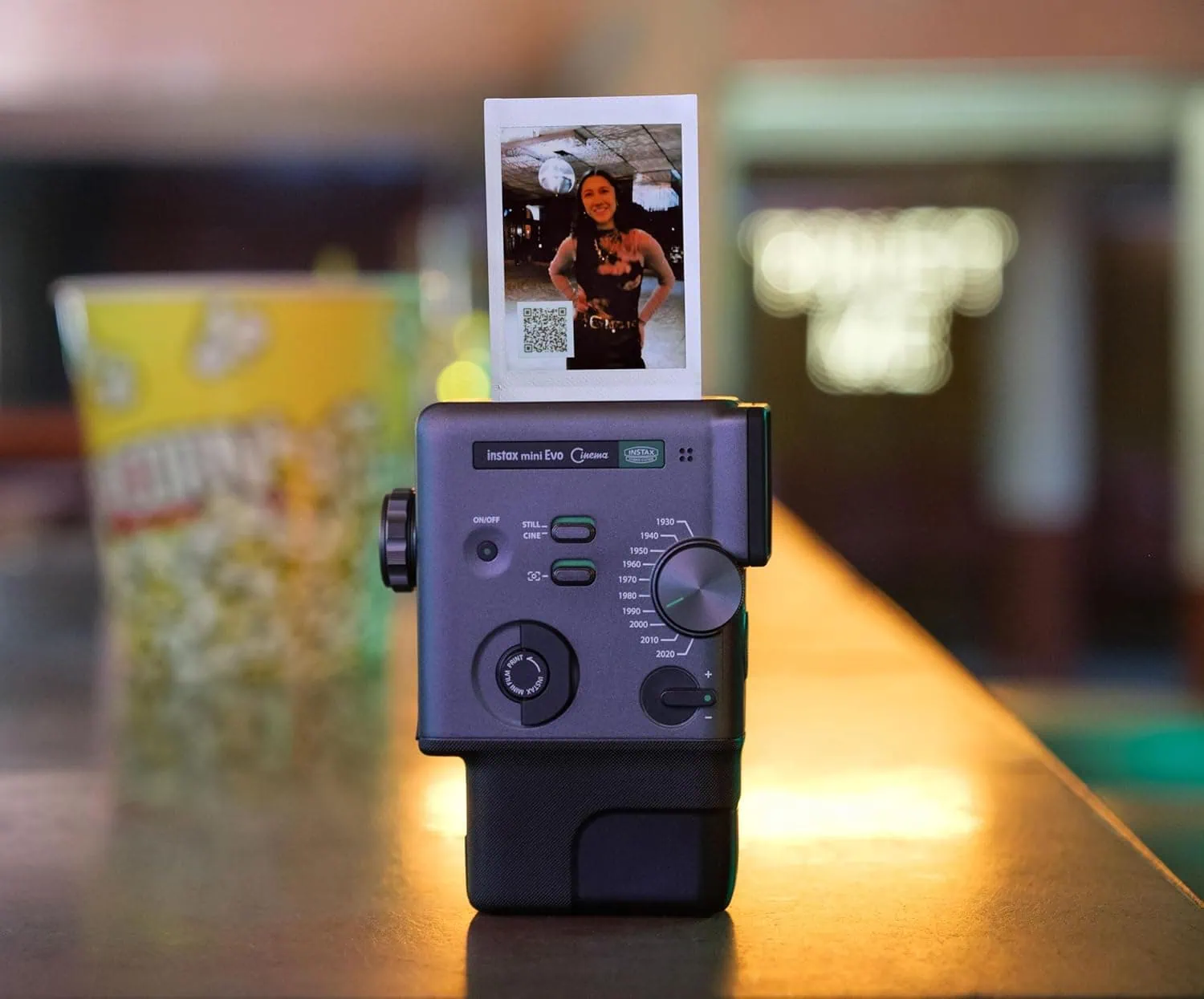 Fotocamera istantanea con foto stampata, scatto in primo piano, sfondo sfocato, tecnologia di stampa.