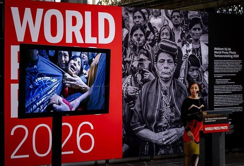 Immagine di un'esposizione con fotografie di reportage e un grande pannello con il logo "WORLD PRESS.
