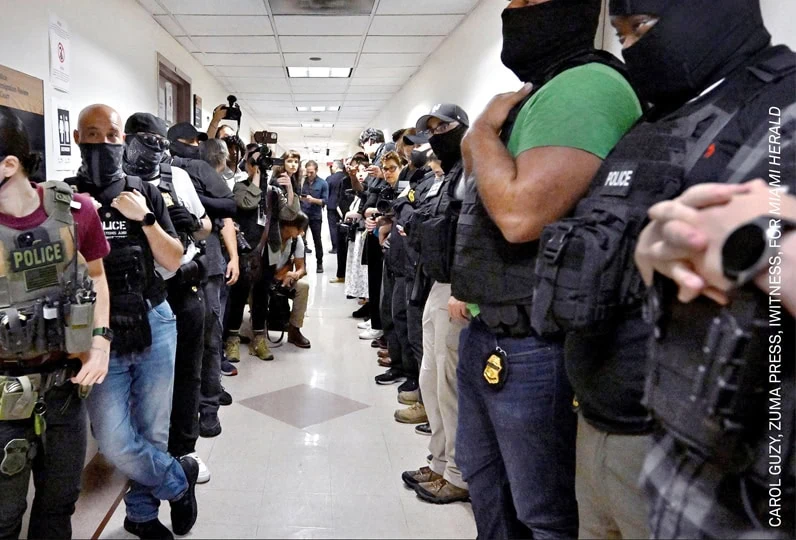 Polizia in tenuta anti sommossa durante manifestazione in un edificio.
