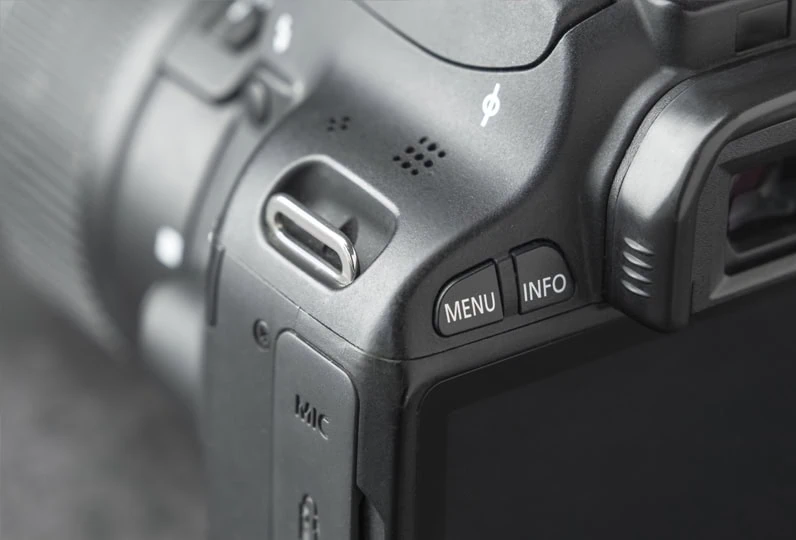 Fotocamera digitale con display e controlli, primo piano di dettagli tecnici e pulsanti.