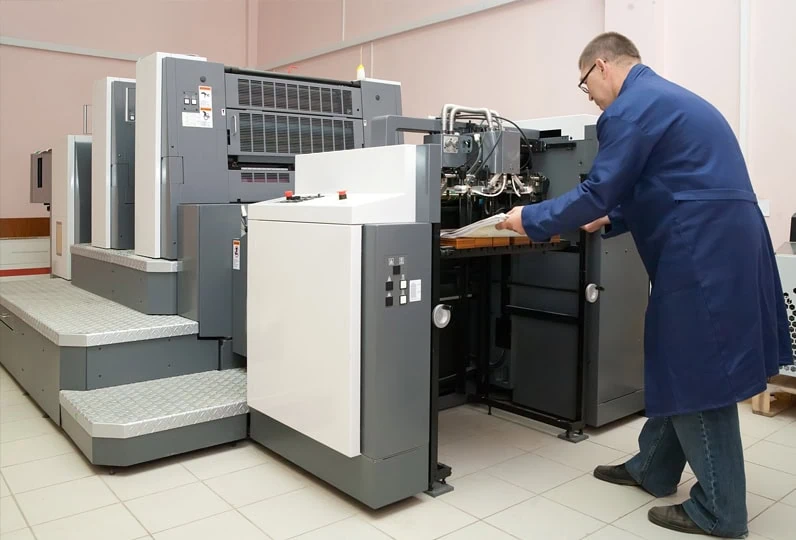 Operatore al lavoro con stampante fotografica di alta qualità in laboratorio.