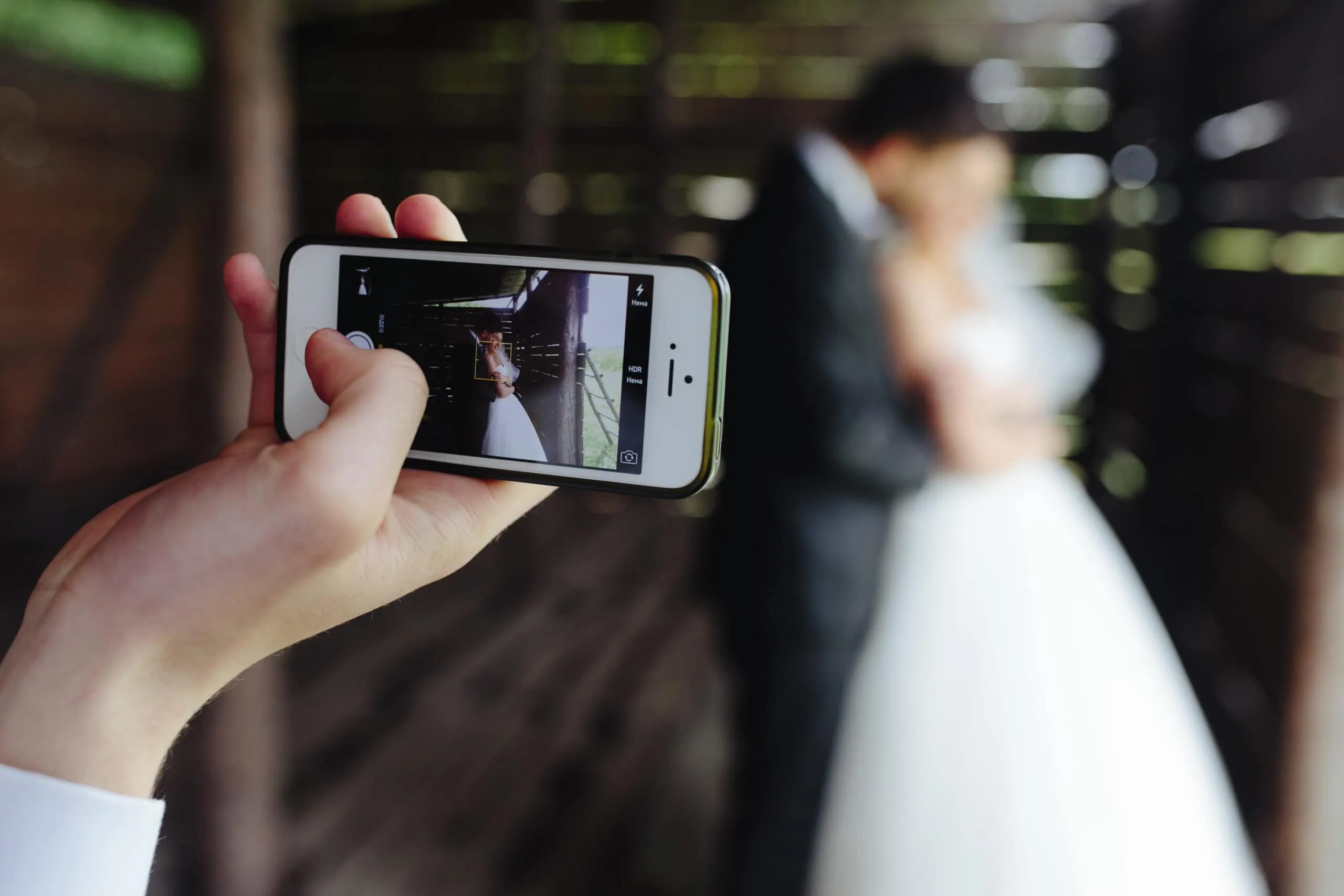 Coppia di sposi che si scatta una foto con uno smartphone.